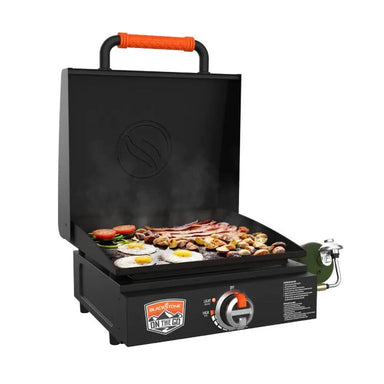 Open Blackstone griddle with breakfast foods and green propane tank attached
