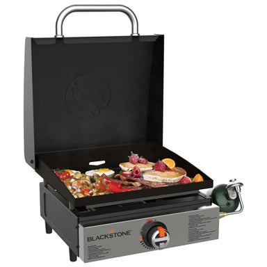 Blackstone 17-inch griddle with hood cooking breakfast foods like pancakes, bacon, and eggs on flat top surface