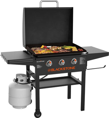 Blackstone 28-Inch Omnivore Griddle with Hood grilling meats and vegetables on backyard patio