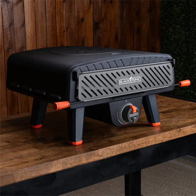 Compact Leggero Pro outdoor pizza oven on tabletop with closed front panel and modern black-orange design