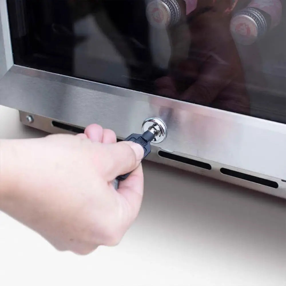 Close-up of Summerset 15" wine cooler lock mechanism with a hand inserting the key on the bottom panel.