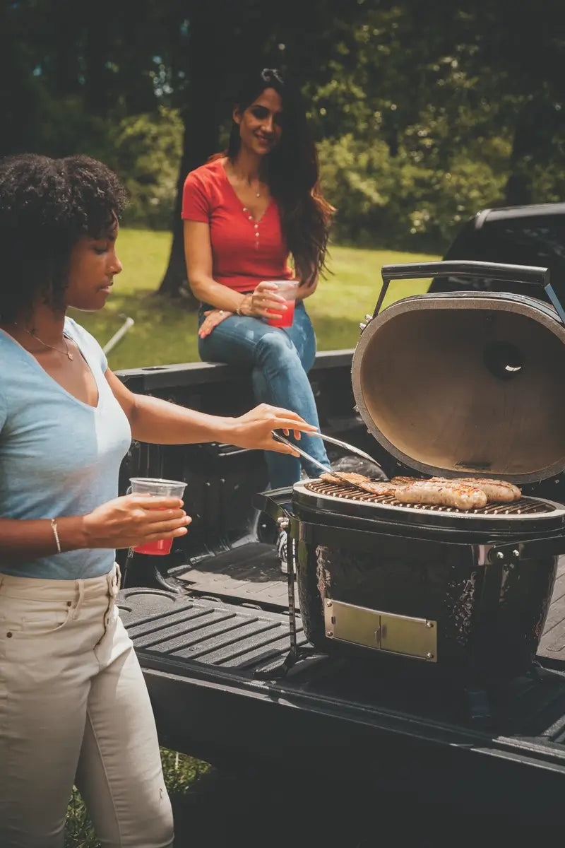 Outdoor tailgate BBQ with kamado grill and drinks