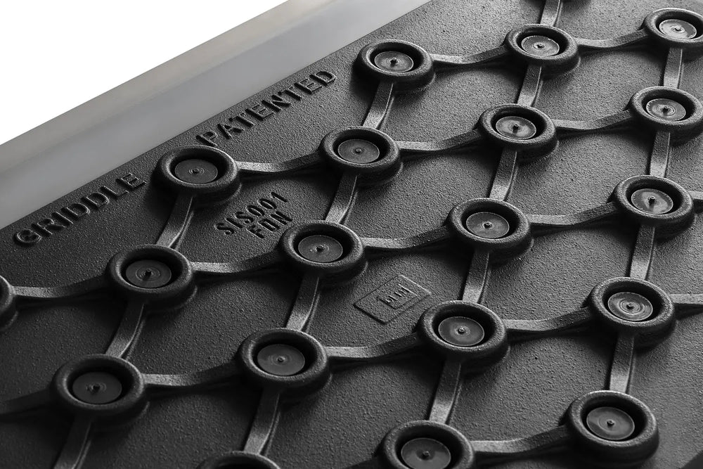 Close-up of patented cast iron Le Griddle cooking plate design for even heat distribution.