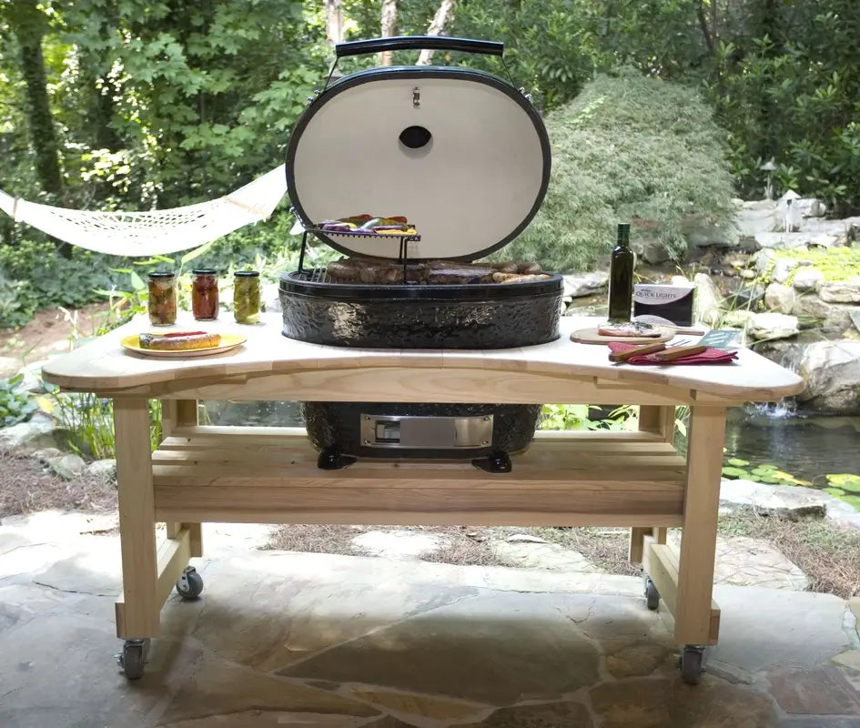 Primo ceramic grill on custom wood cart in backyard garden