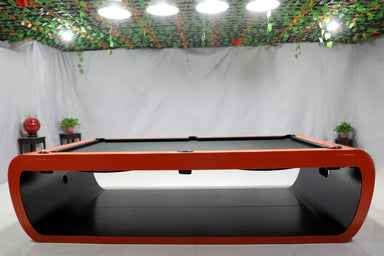 Front view of White Billiards Aldo table in red base and black felt top, placed under pendant lights in a modern game room.