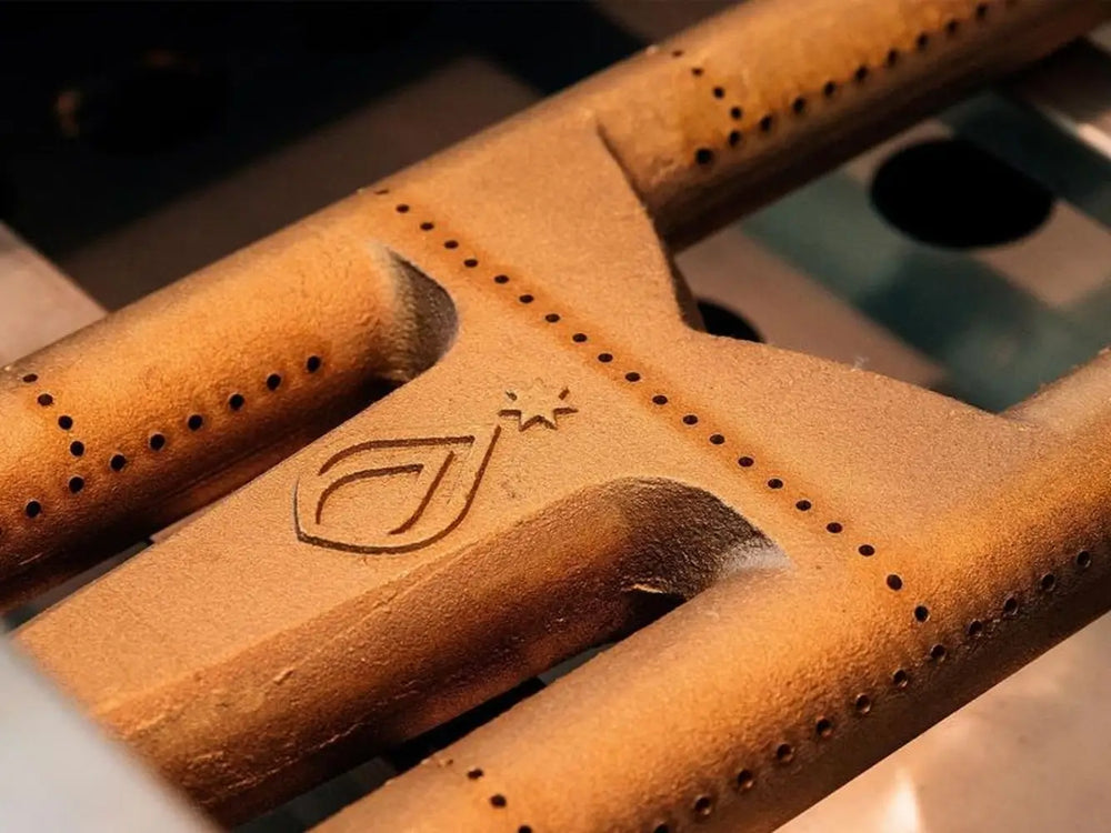 Cast brass U-burner with premium grill logo detail