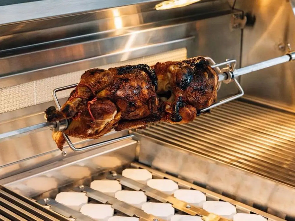 Rotisserie chicken cooking over ceramic briquette grill