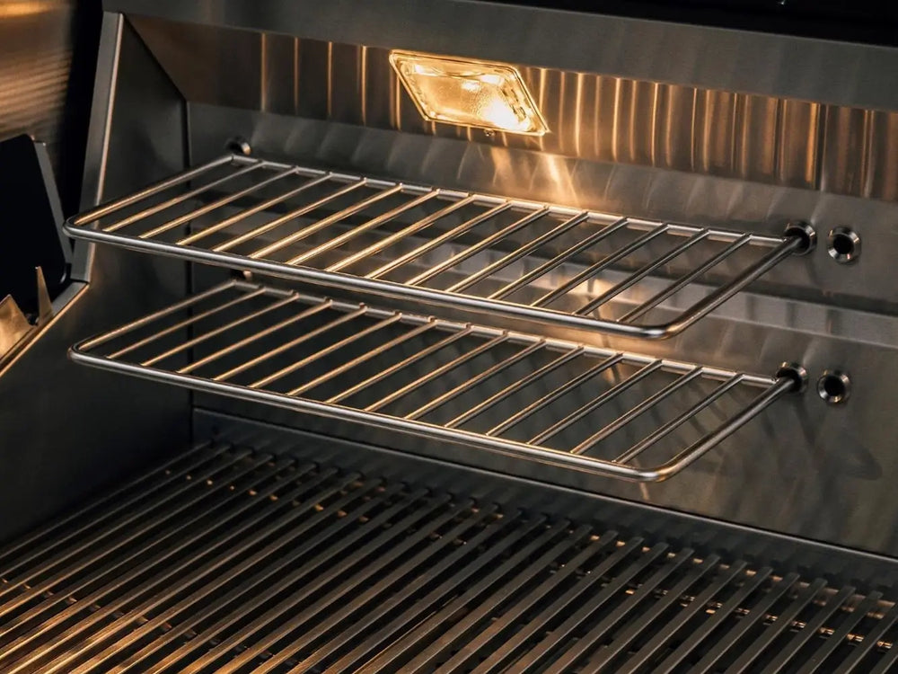 Warming rack with integrated halogen lighting inside stainless steel grill for versatile cooking.