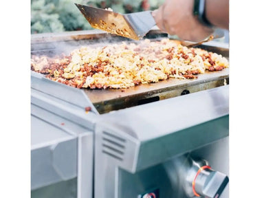 Cooking scrambled eggs and meat on stainless steel flat top outdoor griddle