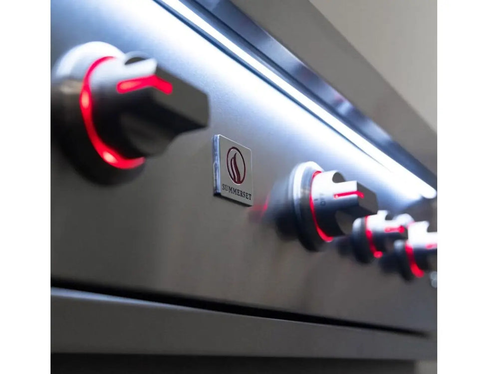 Close-up of Summerset grill control knobs with red LED lights on stainless steel panel.