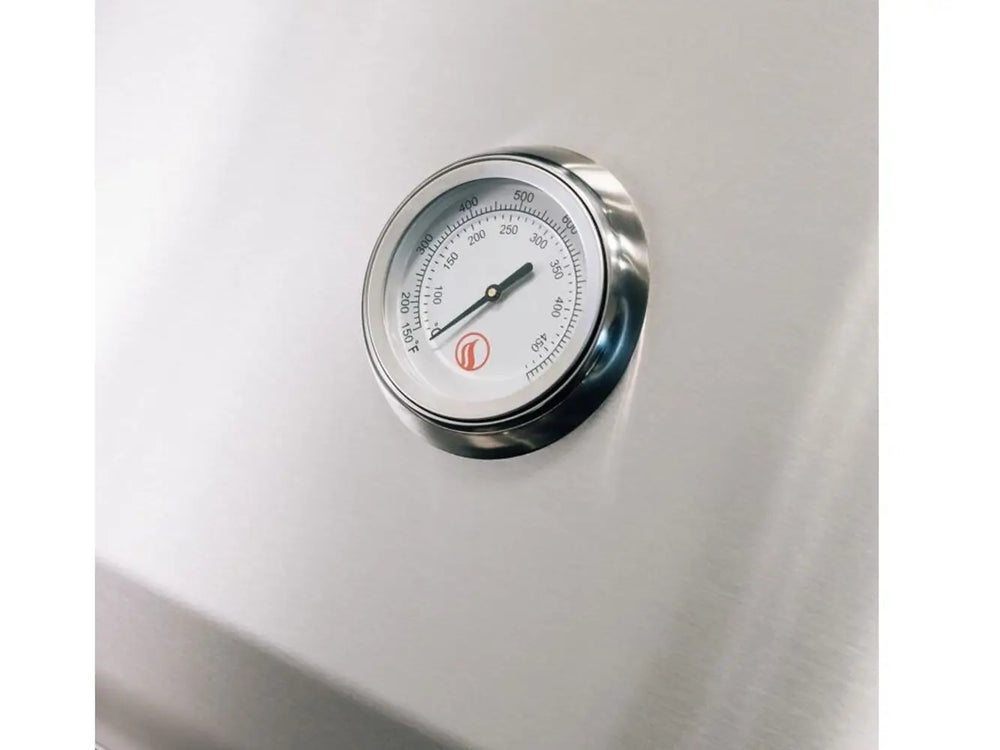 Close-up of built-in stainless steel temperature gauge on outdoor gas grill lid.