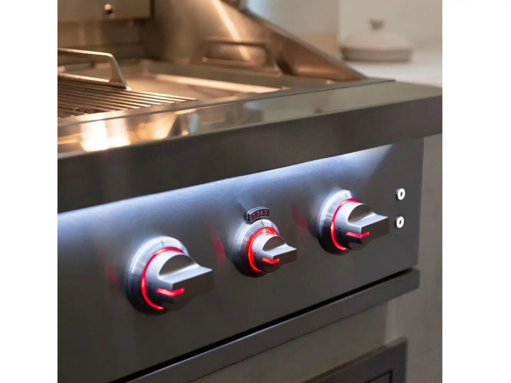 Red-illuminated grill control knobs on stainless steel panel with interior cooking area visible.