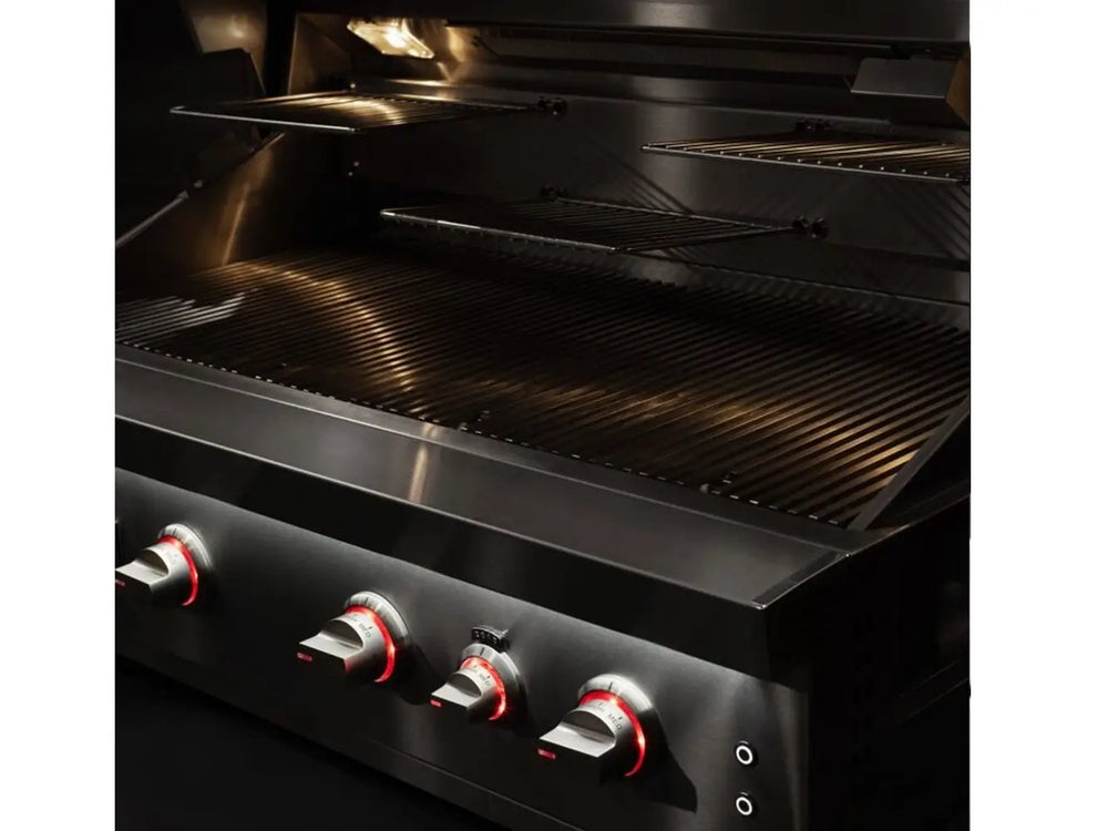 Luxury outdoor grill interior with illuminated cooking grates and control knobs glowing red.