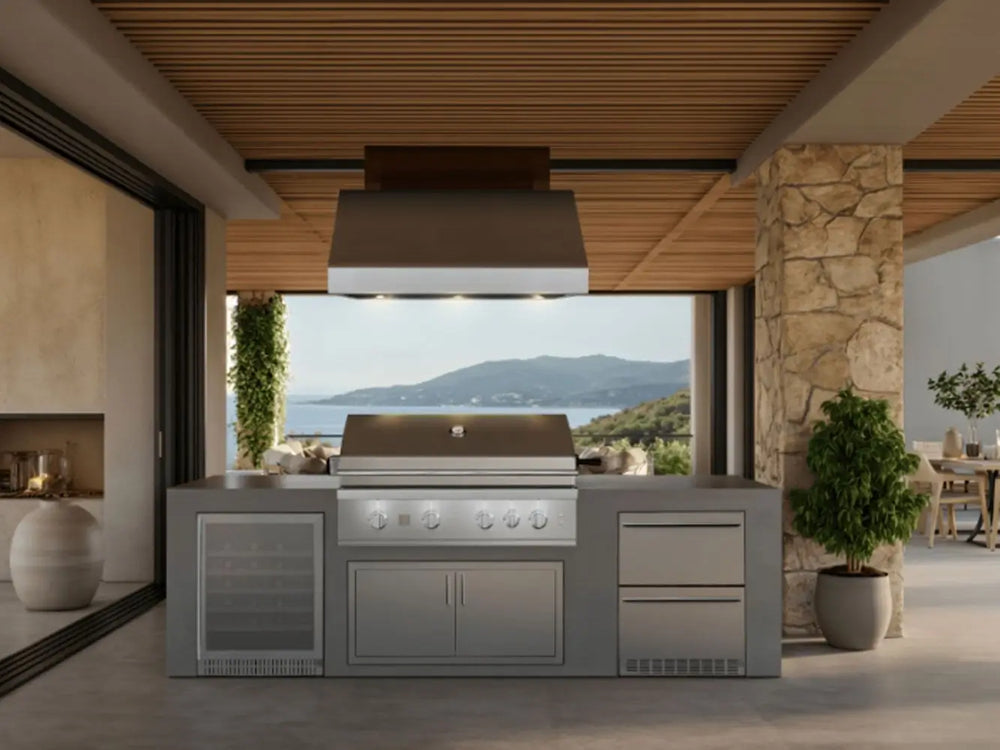Luxury covered patio with built-in stainless steel gas grill and ocean view in the background.