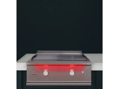 True Flame built-in gas griddle installed in an outdoor kitchen with stainless steel construction and red LED-lit control knobs.