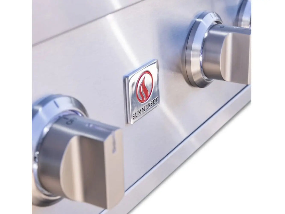 Close-up of stainless steel control knobs with Summerset logo on outdoor gas grill panel.