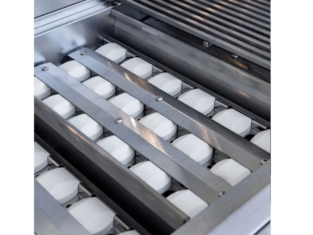 Ceramic briquette trays inside stainless steel outdoor gas grill for even heat distribution.