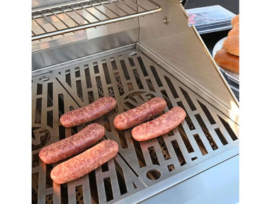 Close-up of Wildfire Gas Grill cooking sausages on stainless steel grates with warming rack above