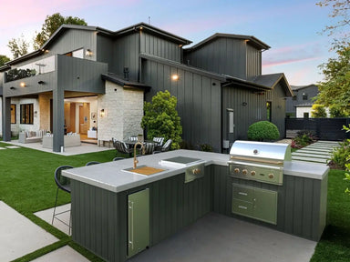 Wildfire 36-Inch Built-In Gas Grill installed in modern outdoor kitchen with seating area and backyard view