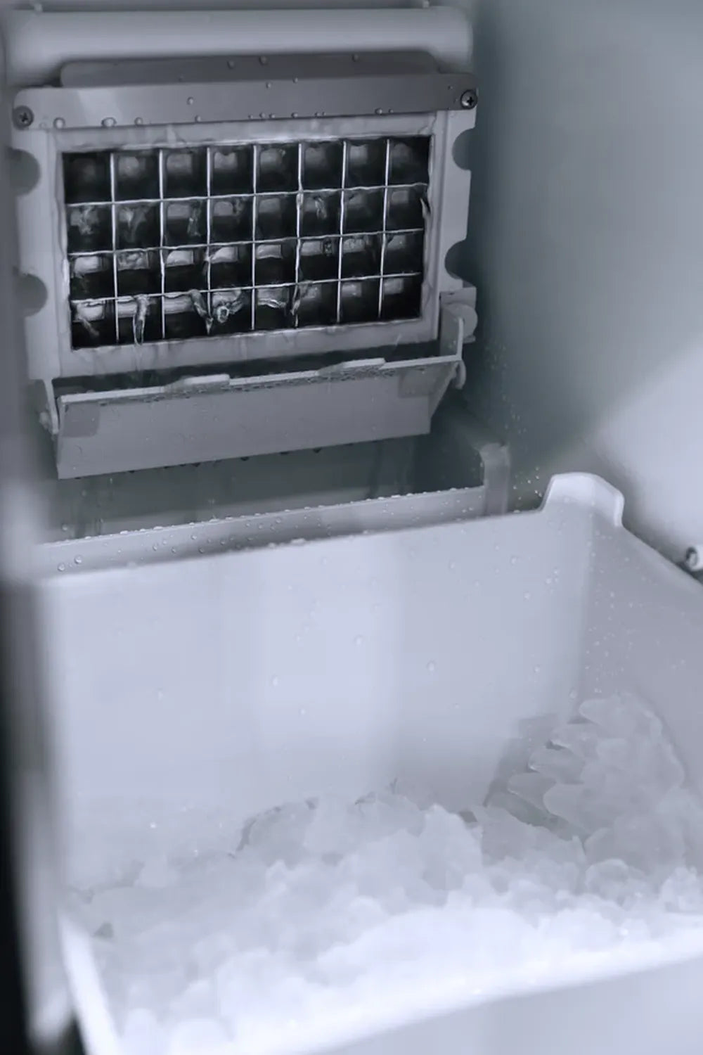 Close-up of clear ice cubes being harvested from the evaporator grid in a Summerset ice maker.