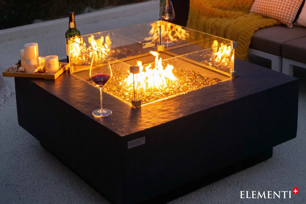 Close-up of Bergen fire table glass wind guard and slate black GFRC texture.