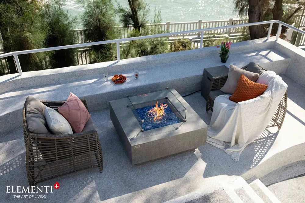Elementi Plus OFG413LG Victoria space gray fire table on a luxury patio.
