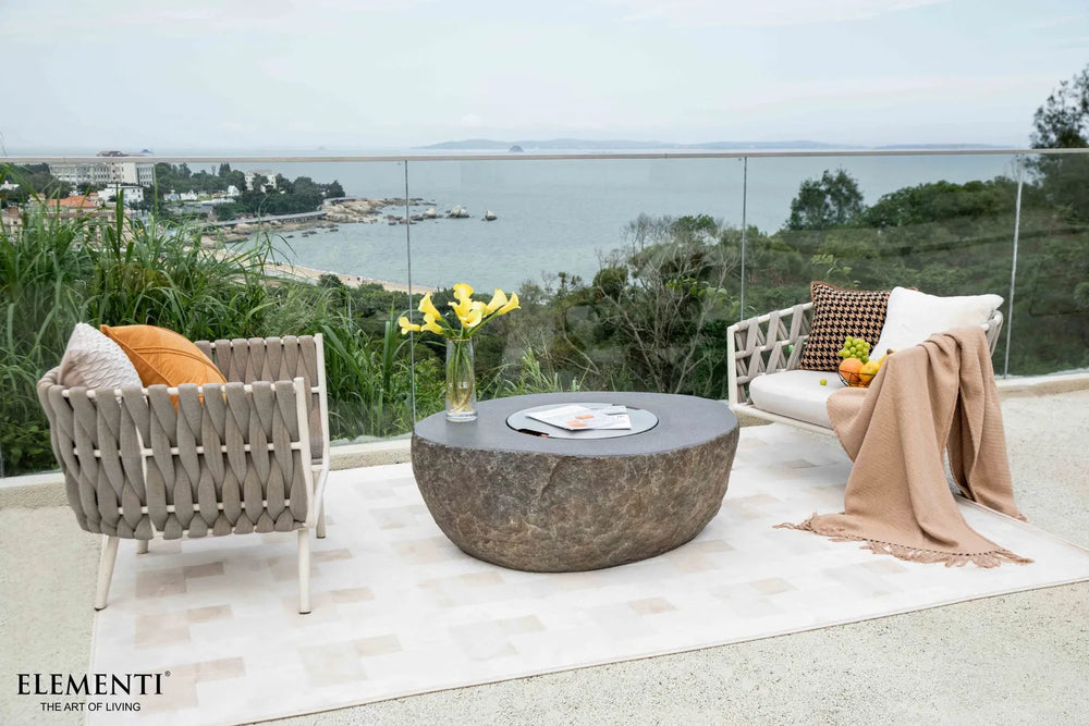 Boulder fire table used as a functional coffee table with its stainless steel burner lid in place.