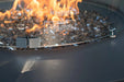 Close-up of Elementi Plus Nimes fire table glass wind guard with safety warning text.