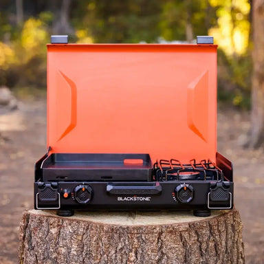 Side profile of compact camping griddle with integrated burner and orange accents