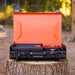 Side profile of compact camping griddle with integrated burner and orange accents