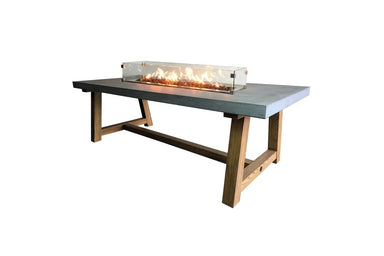 Lit Elementi OFG201 Sonoma Dining Fire Table 45k BTU with lava rocks and orange flames on white background.