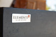 Elementi logo badge on dark gray concrete-style fire table surface.