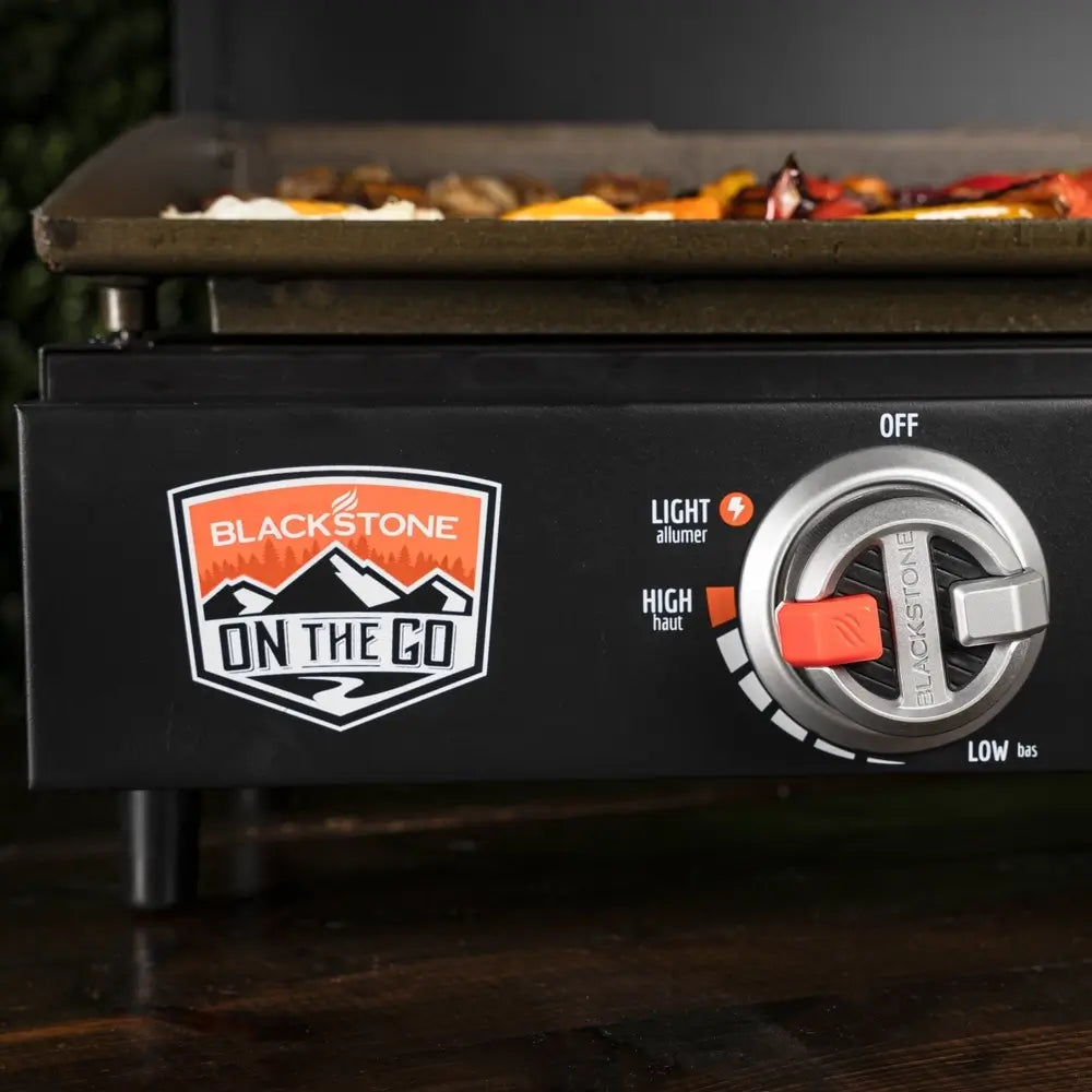 Close-up of control knob and Blackstone On The Go logo on griddle front panel