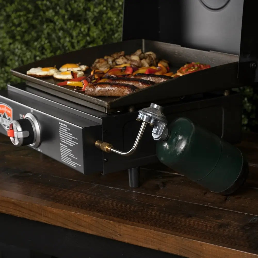 ide view of compact tabletop griddle with propane tank and sizzling breakfast