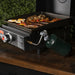 ide view of compact tabletop griddle with propane tank and sizzling breakfast