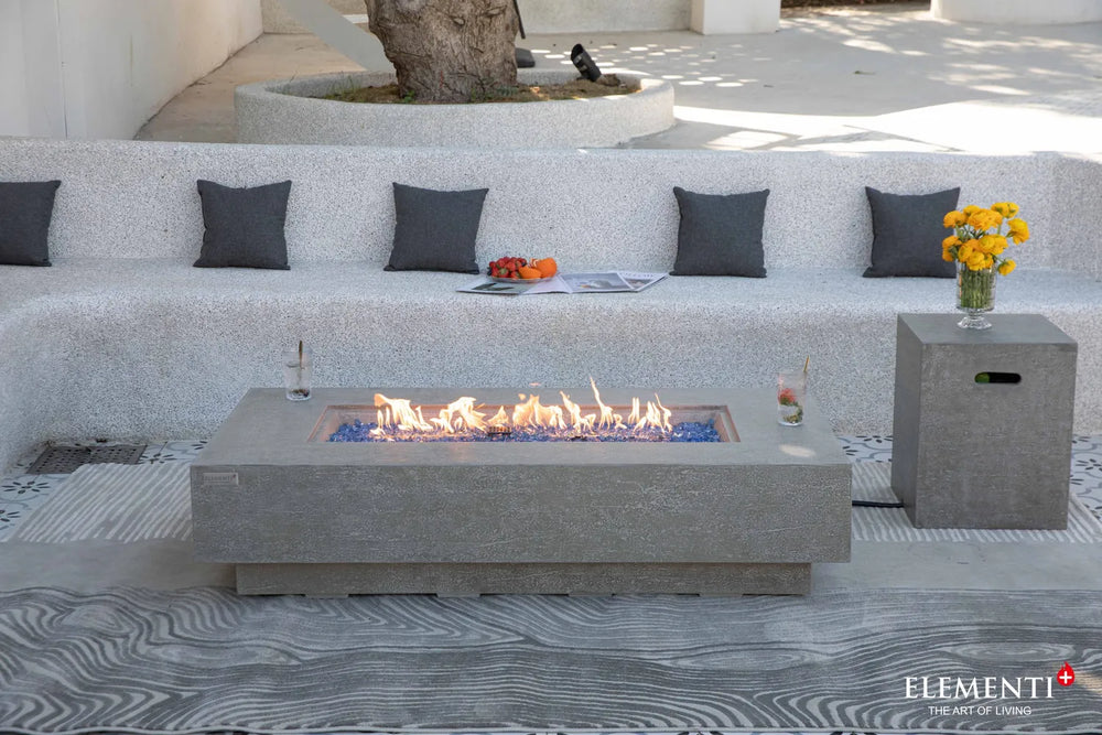 Elementi Plus Riviera light gray fire table in modern outdoor seating area with built-in bench.