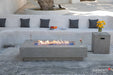 Elementi Plus Riviera light gray fire table in modern outdoor seating area with built-in bench.