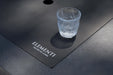 Elementi logo on dark gray fire table surface with burner cover installed.