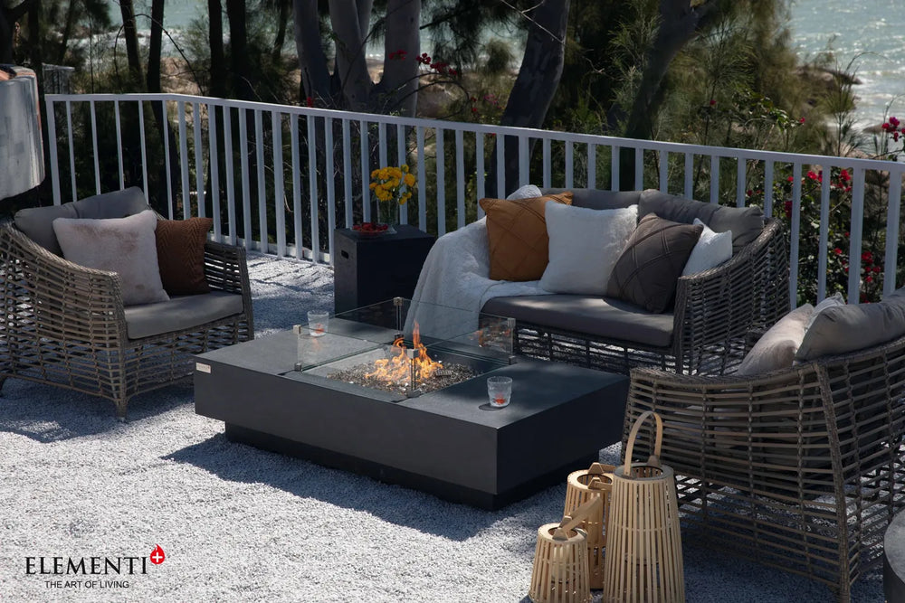 Elementi Plus Cannes dark gray fire table with glass wind guard in modern outdoor seating area.