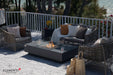 Elementi Plus Cannes dark gray fire table with glass wind guard in modern outdoor seating area.