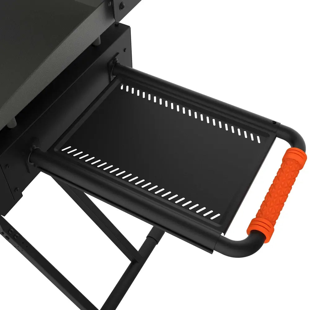 Close-up of Blackstone griddle side shelf with orange handle and steel vented tray for outdoor cooking