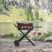 Foldable Blackstone 22" griddle with dual burners and hood set up near mountain lake for camping