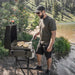 Man using Blackstone 22” outdoor portable flat top griddle to cook sandwiches near scenic lake