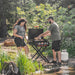 Blackstone 22-inch gas griddle with hood grilling food at forest campsite with propane tank setup