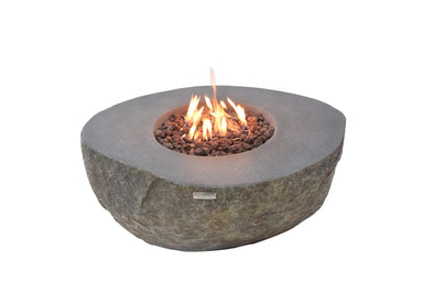 Elementi Boulder fire table featuring a realistic hand-crafted rock texture and active flames flickering over lava rocks.