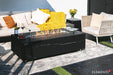 Detail shot of the Varna Bulgaria Black fire table used as a luxury coffee table with the burner lid in place, styled with a wine bucket, champagne, and snacks.