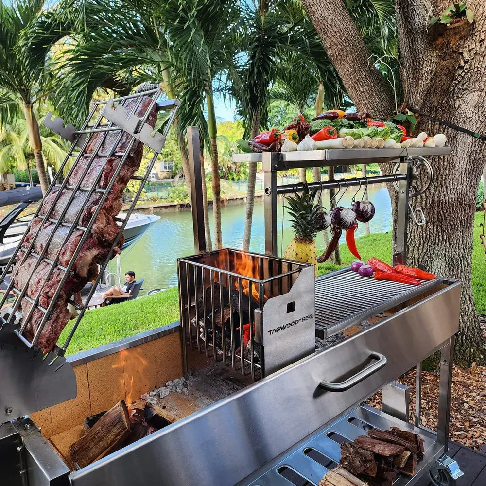 Tagwood BBQ06SS Santa Maria grill cooking meats over wood fire by waterfront backyard