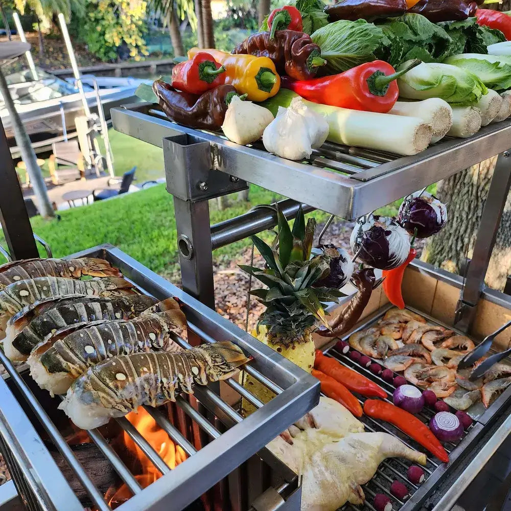 Tagwood BBQ06SS Santa Maria grill cooking lobster tails, shrimp and vegetables over charcoal