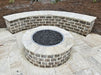 Elevated view of a Travertine TessaRai 46" Round Gas Fire Pit with a matching curved stone seating wall on a travertine tile patio.