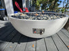 Travertine TessaRai 40 inch Patio Fire Pit Kit with fire glass and manual control panel on outdoor deck overlooking marsh view